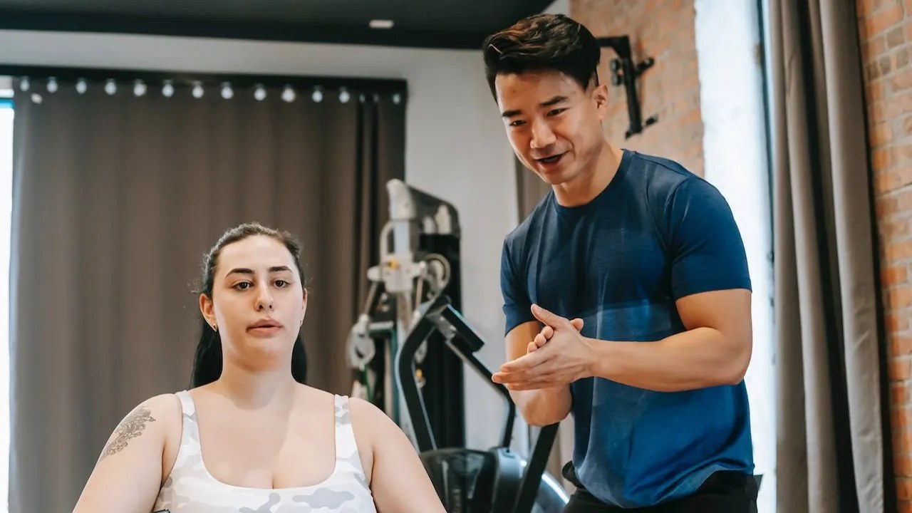 A personal trainer coaching and encouraging a client through a workout